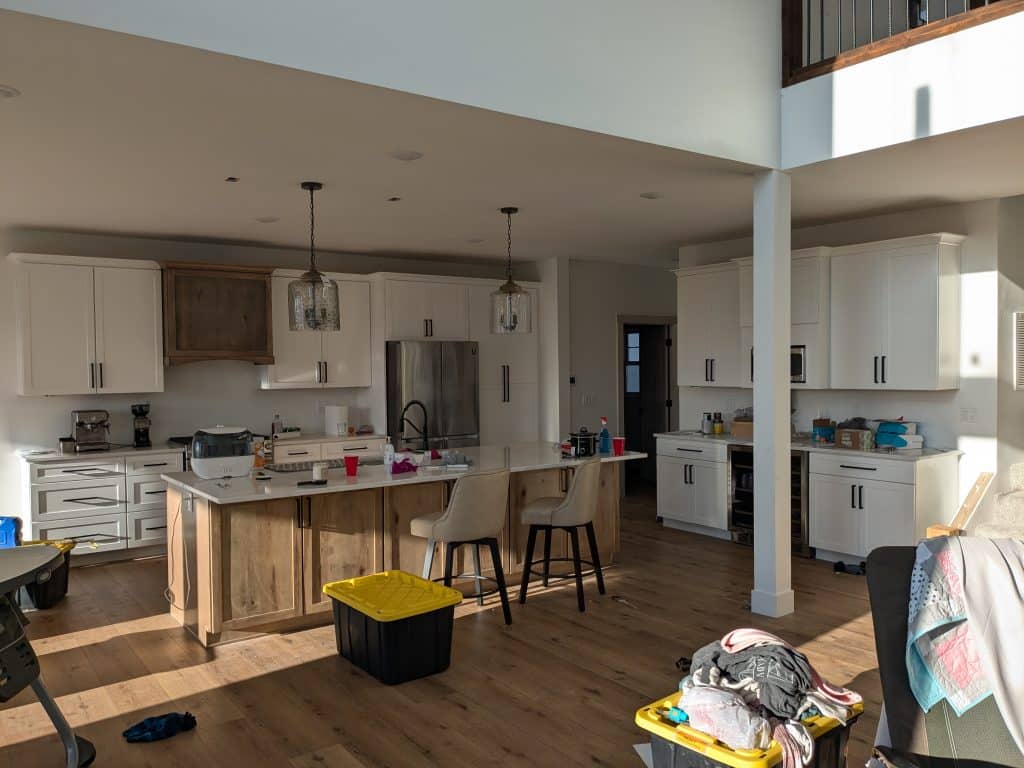 PXL_20241218_211705780 Bright, modern kitchen with island, white cabinets, and wood accents.